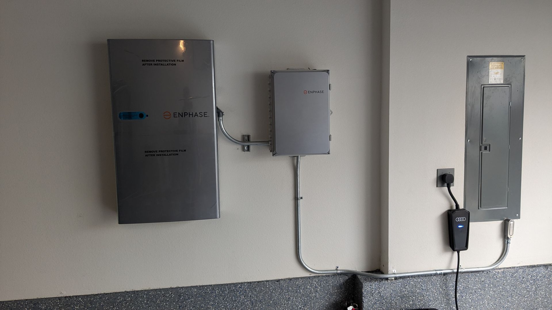 Two electrical boxes are hanging on a wall next to each other.