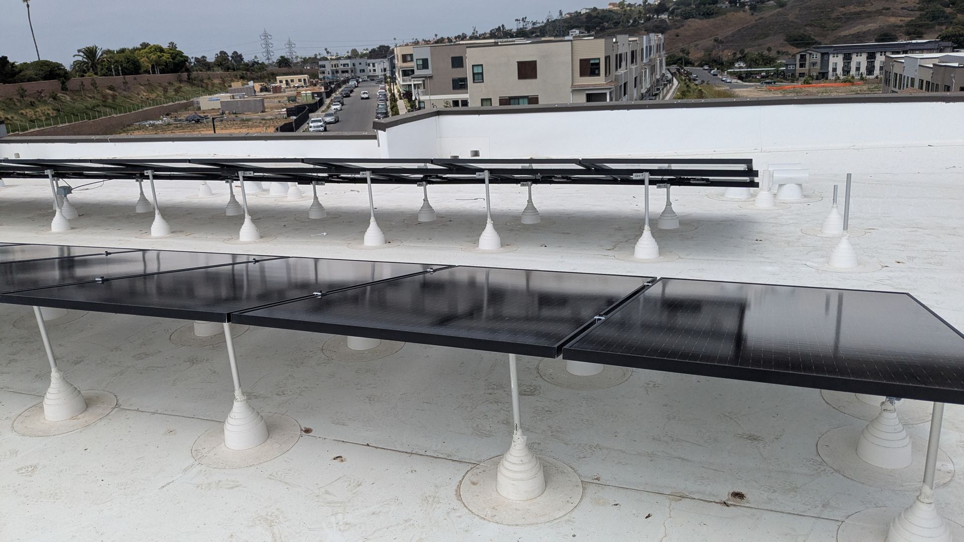 A row of solar panels on top of a white roof
