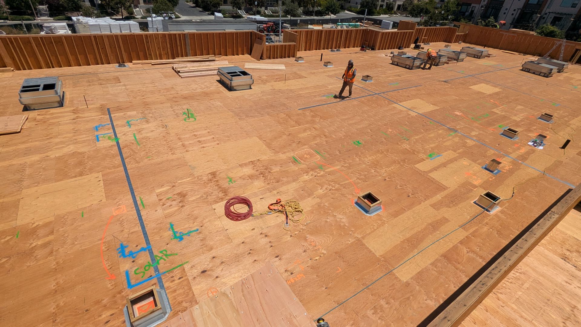 An aerial view of a construction site with a lot of plywood on the ground.