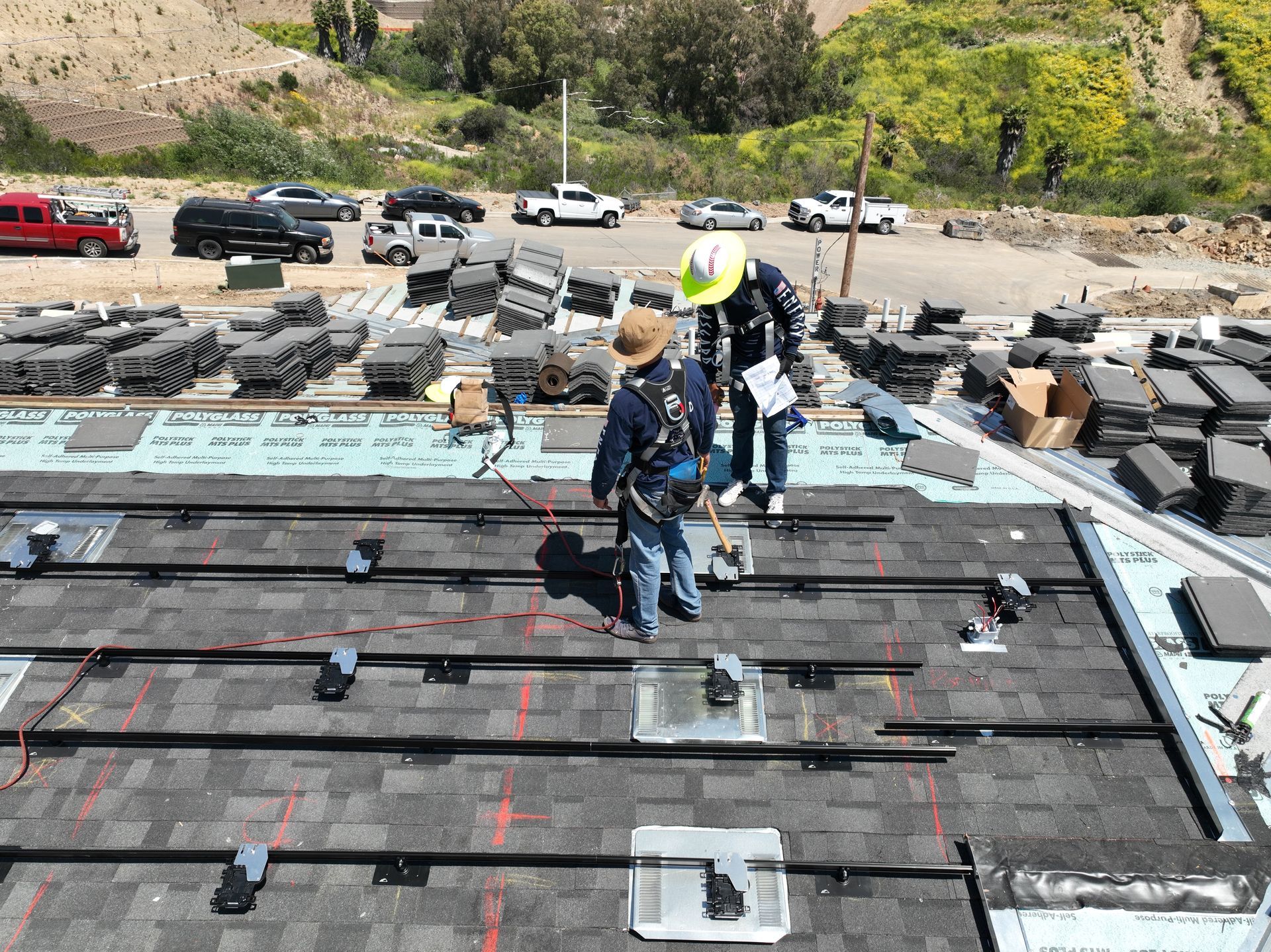 Two men are working on the roof of a building.