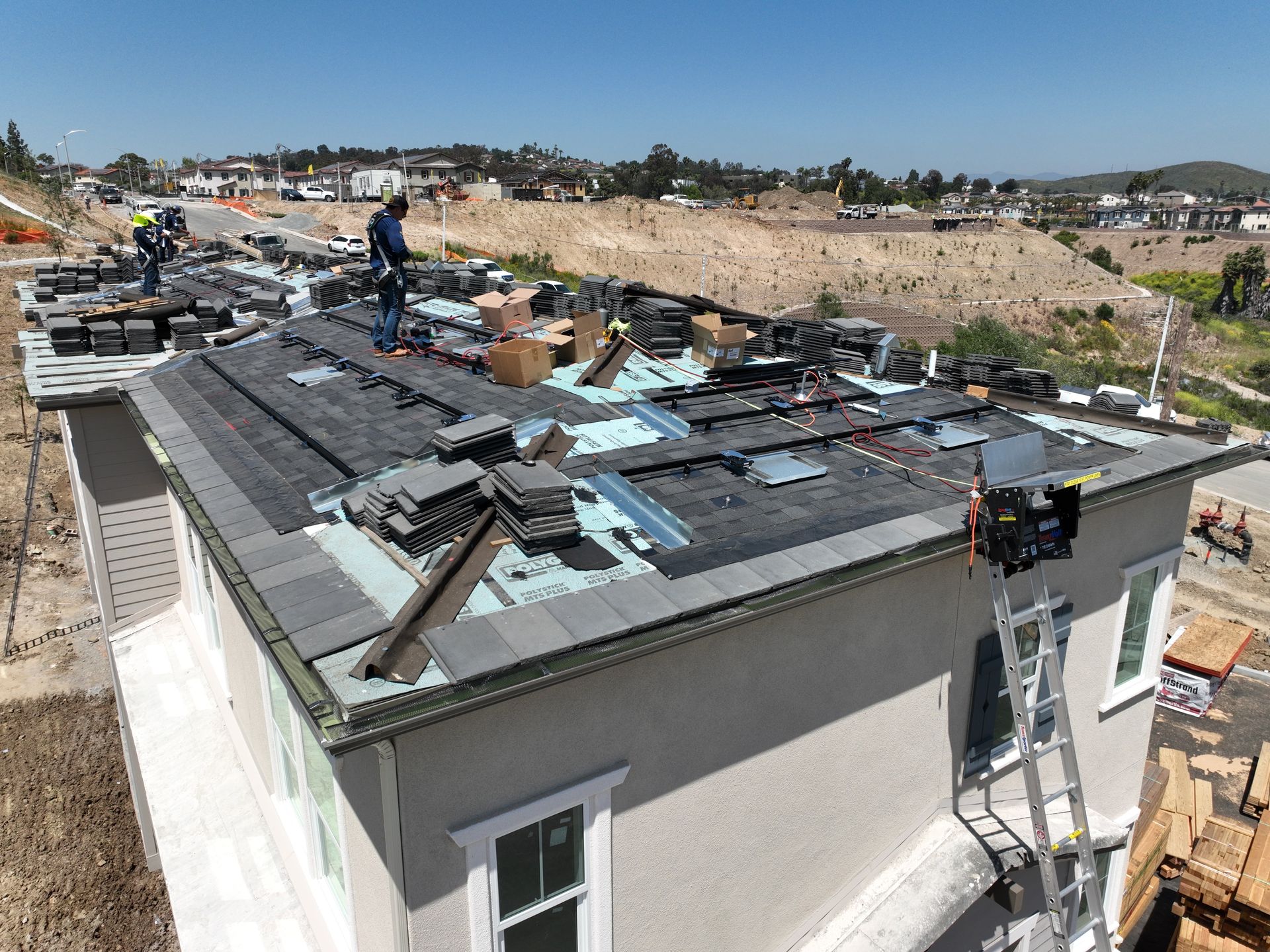 A group of people are working on the roof of a house.