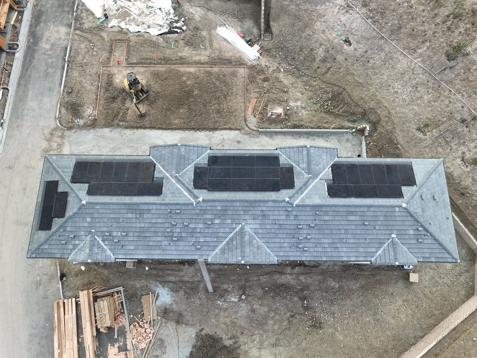 An aerial view of a house with solar panels on the roof.