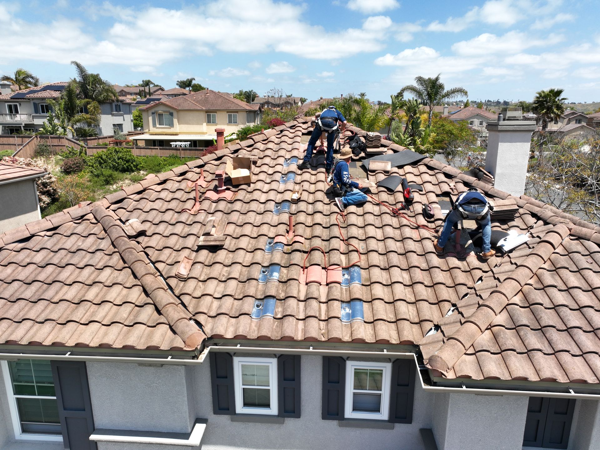 A group of men are working on the roof of a house.
