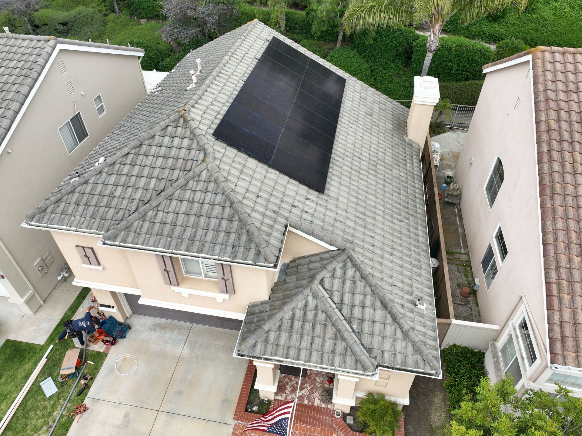 An aerial view of a house with solar panels on the roof.