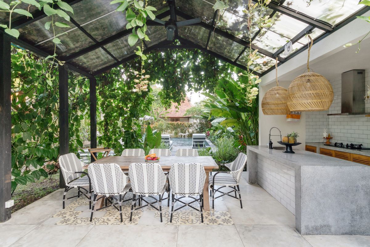 A kitchen with a table and chairs under a glass roof.