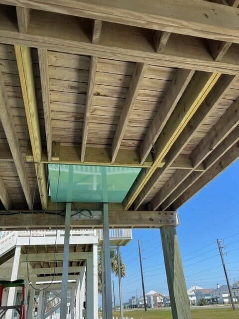 The ceiling of a wooden deck with a passenger lift going through it