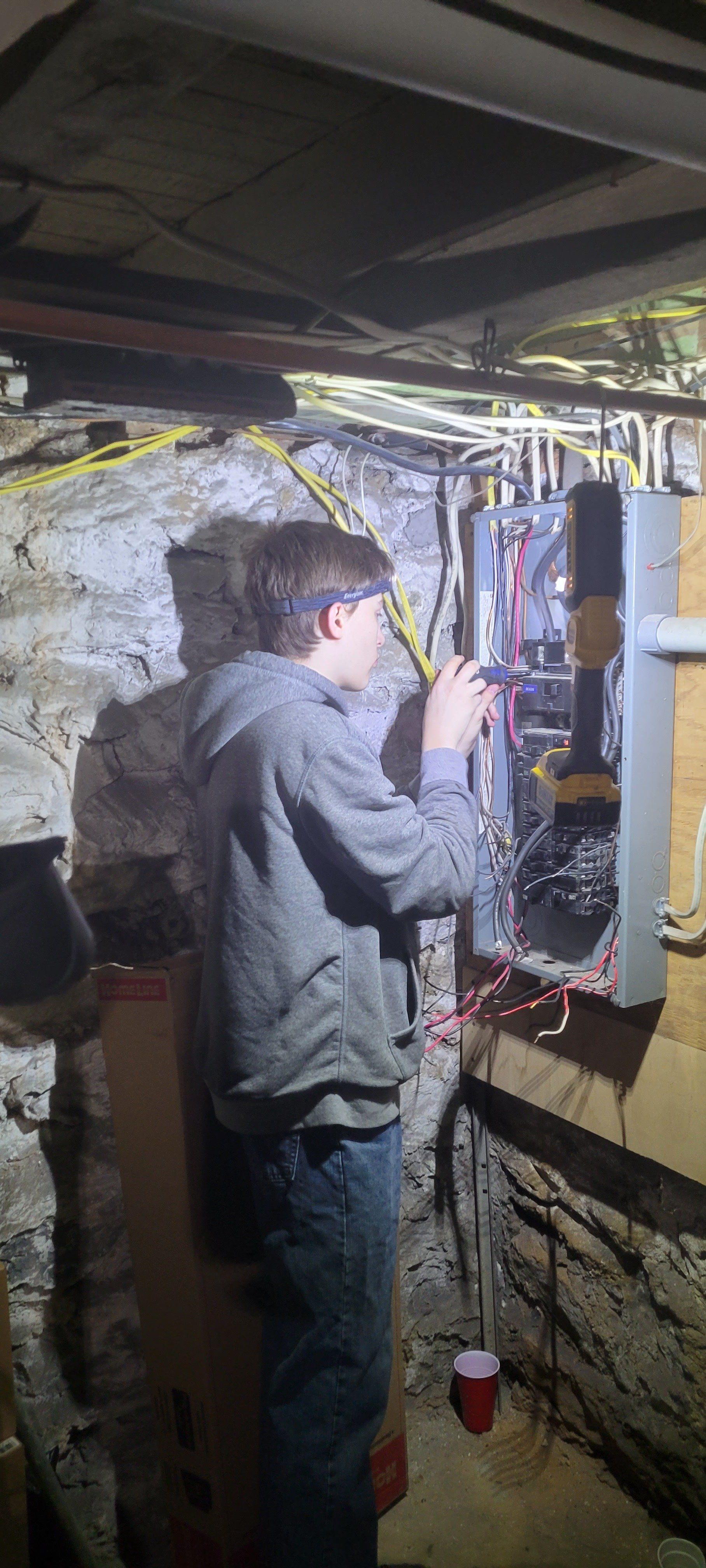 a man is working on an electrical box in a basement .