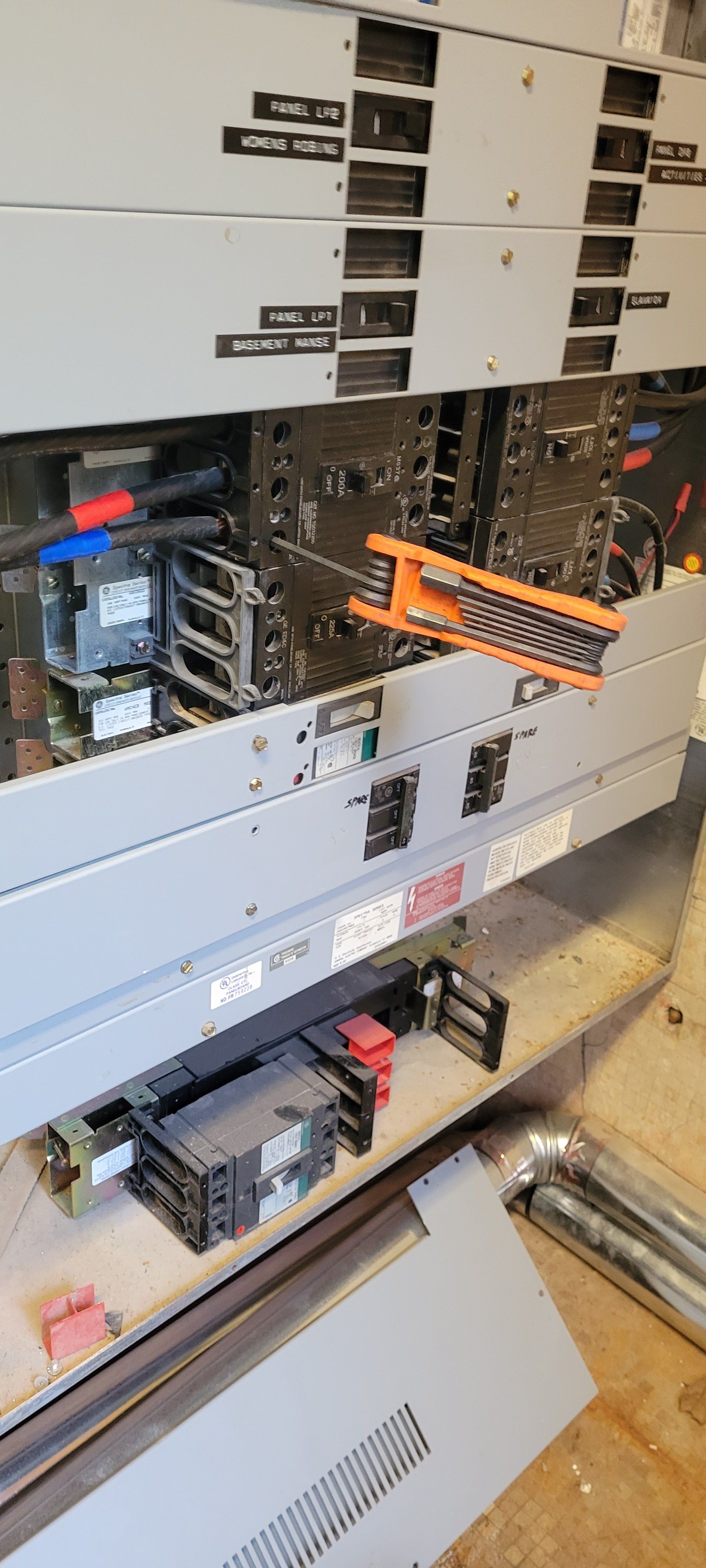 a close up of a electrical panel with a lot of wires coming out of it .