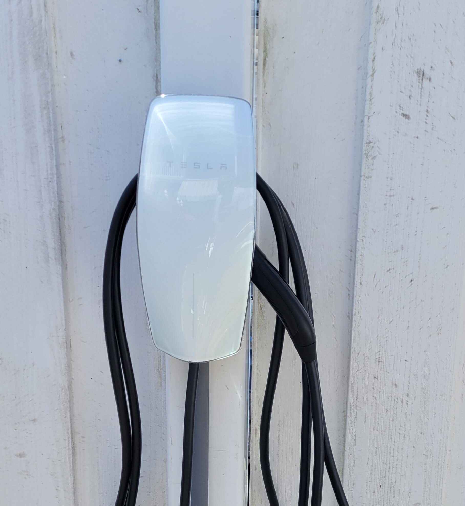 a black cord is hanging from a white pole .