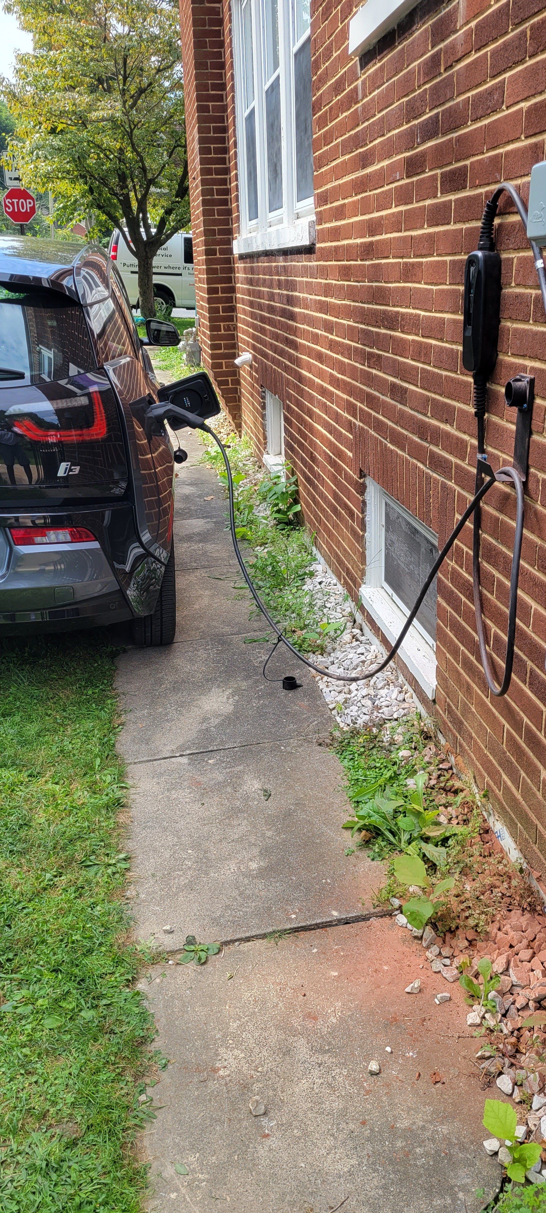a car is parked on the sidewalk next to a brick building .