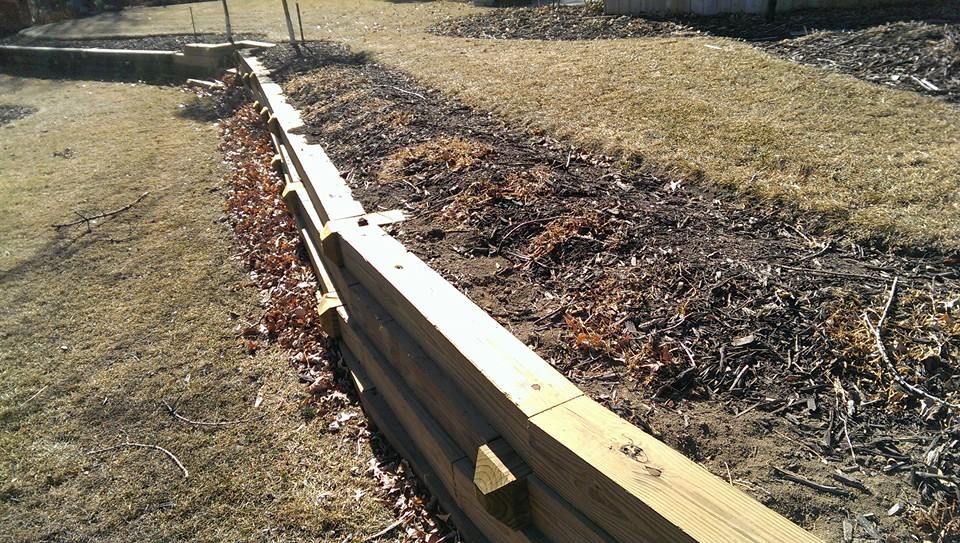 A wooden fence is in the middle of a grassy field