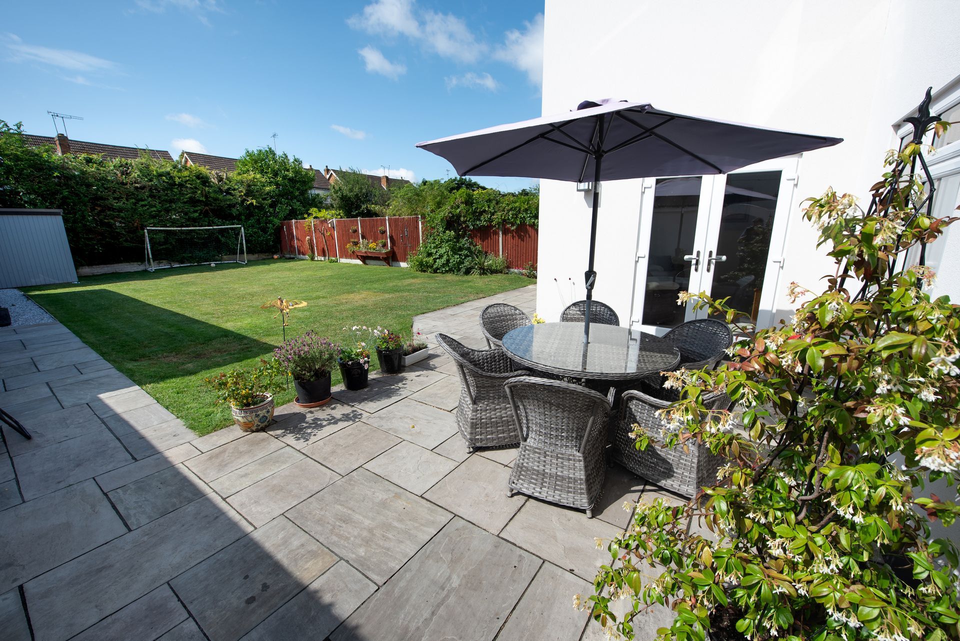 A patio with a table and chairs and an umbrella