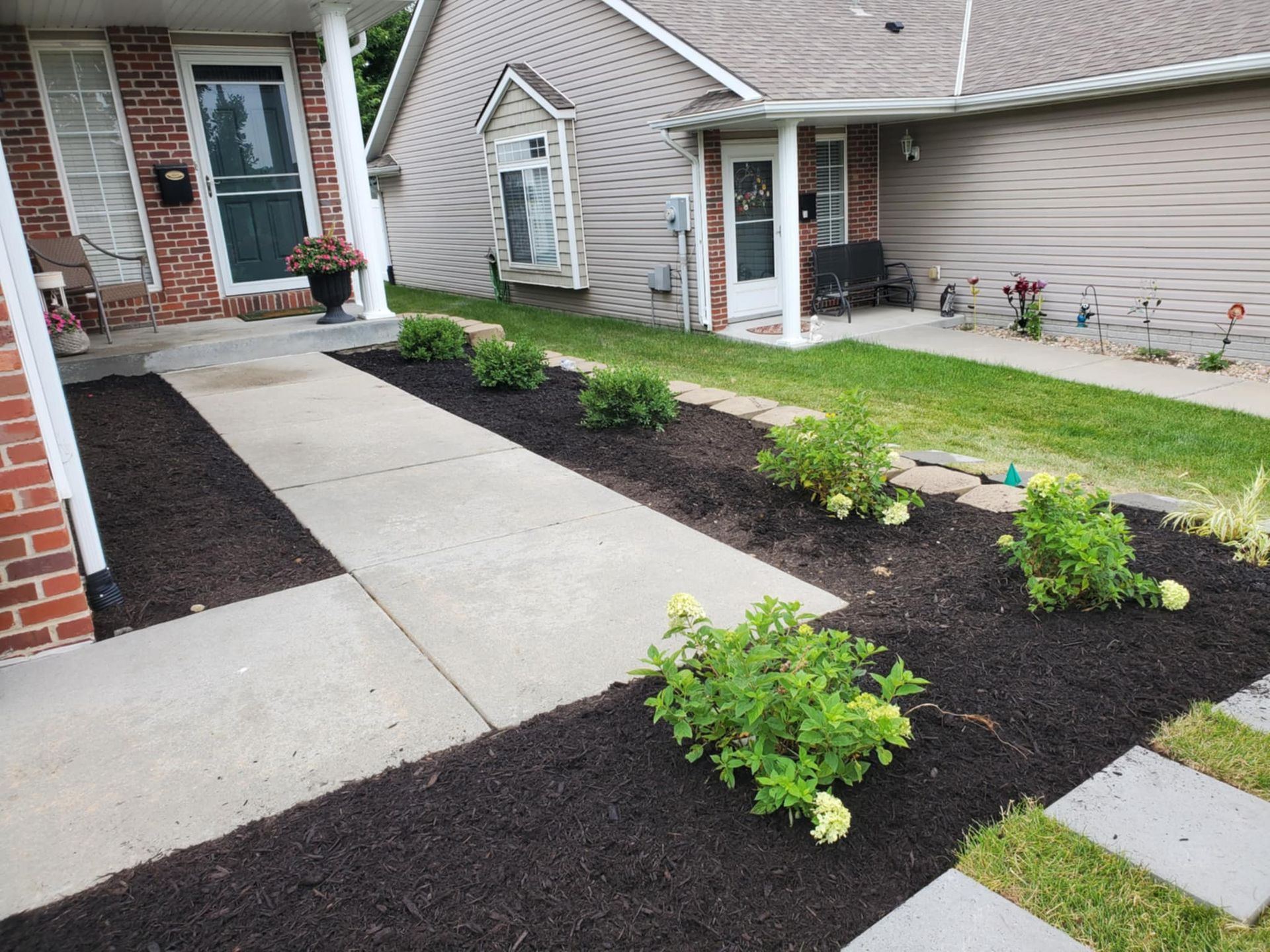 A wooden deck with a couch and chairs under a pergola.