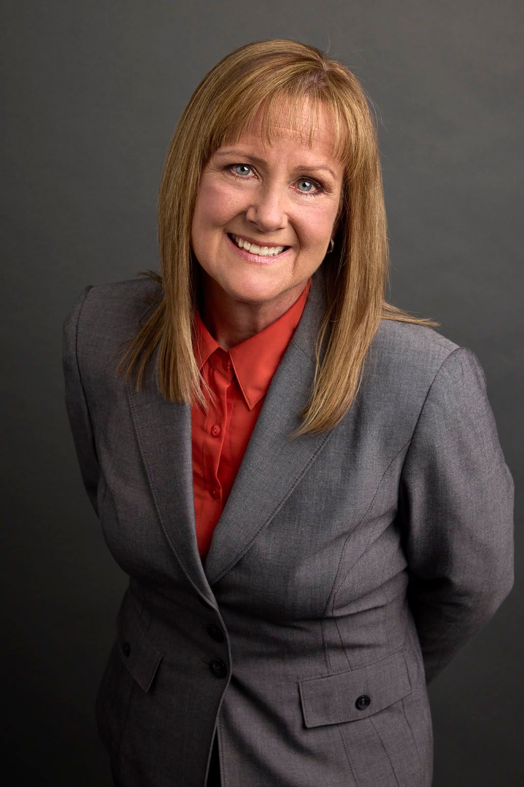 A woman stands in front of a city skyline with the name janice van roy on the bottom