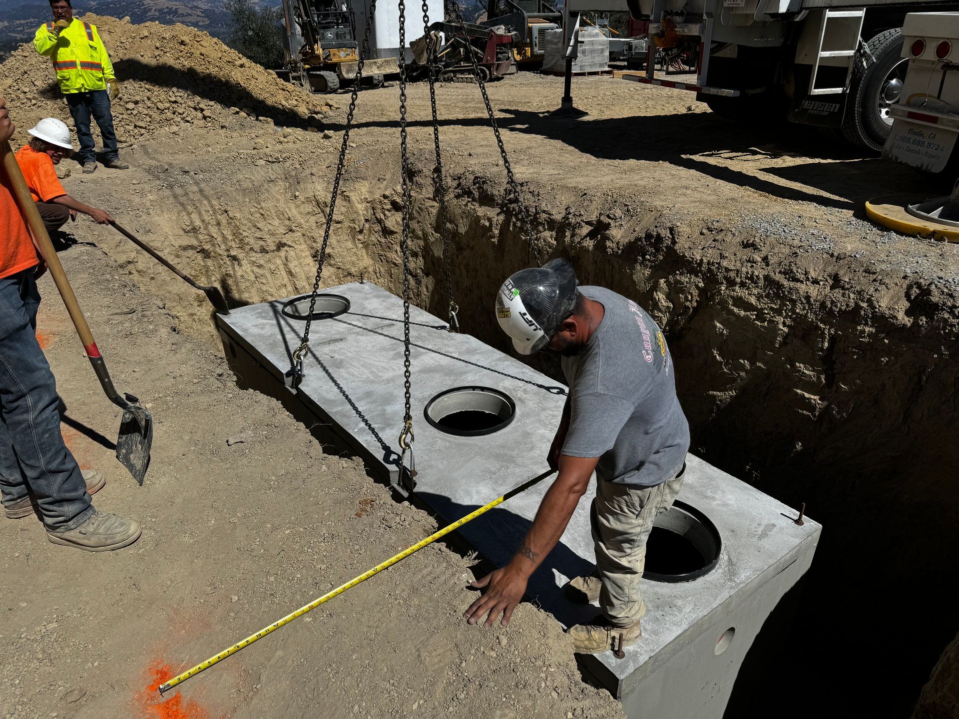 A man is measuring a concrete block with a tape measure.