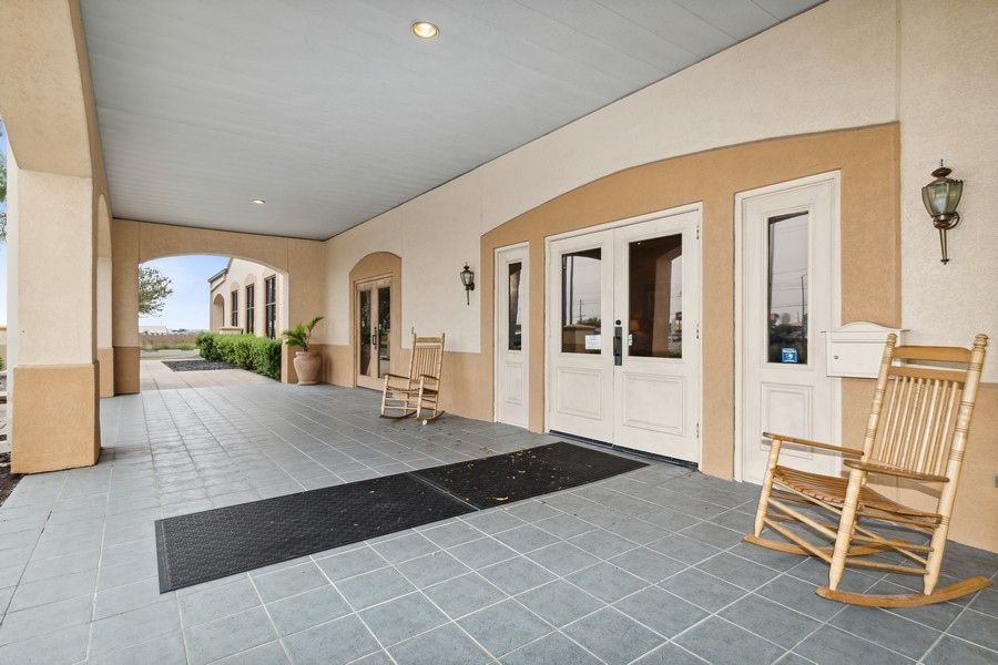 A rocking chair is sitting on a porch in front of a building.