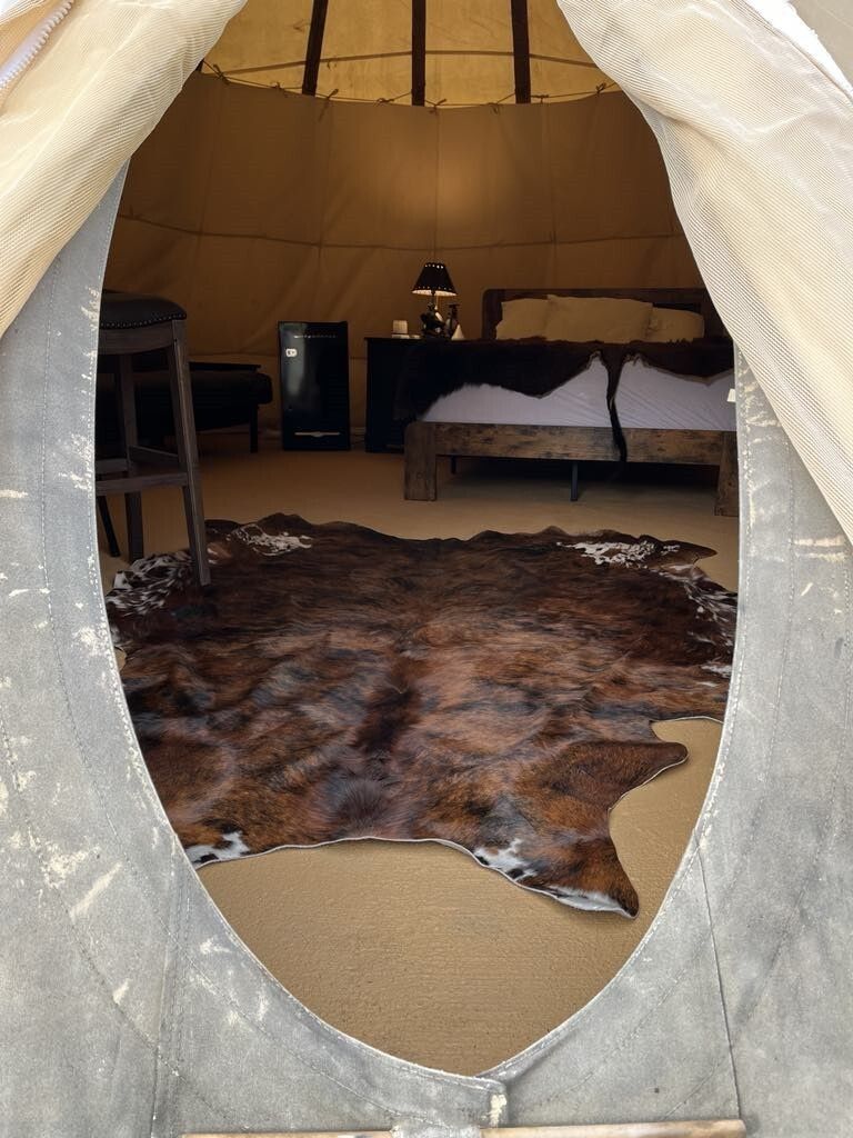A bedroom with a cowhide rug and a bed