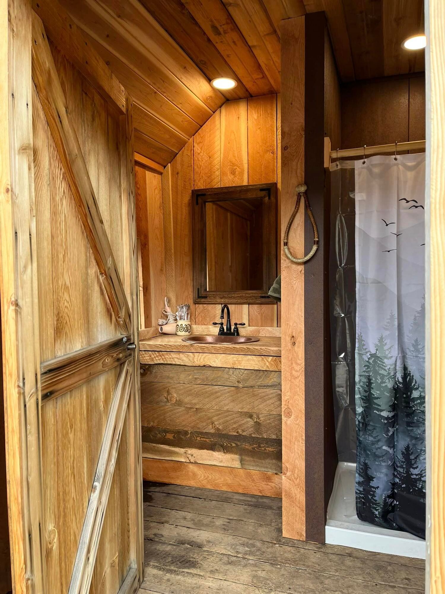 A bathroom with a sink , mirror and shower curtain.