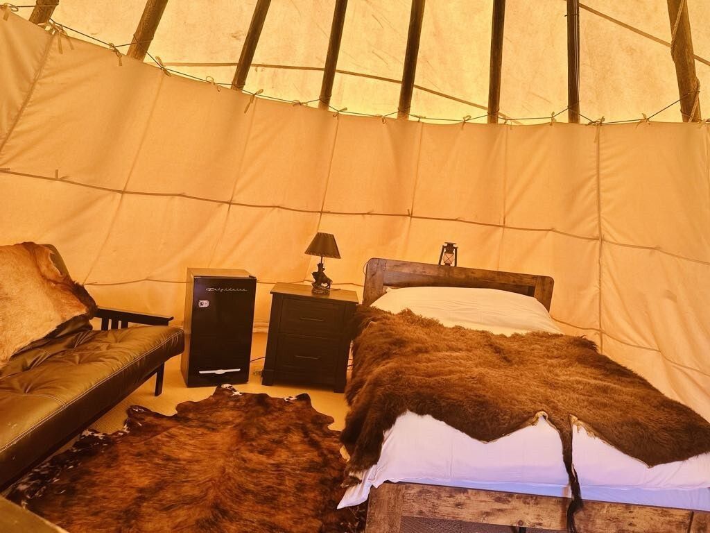 A tent with a bed and a couch in it