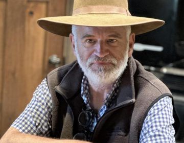 A man with a beard wearing a hat and vest