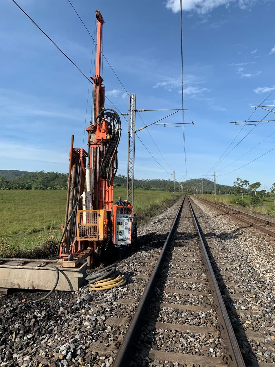 A Drilling Machine Is Parked on The Side of A Train Track — MK Drilling in Rosemount, QLD