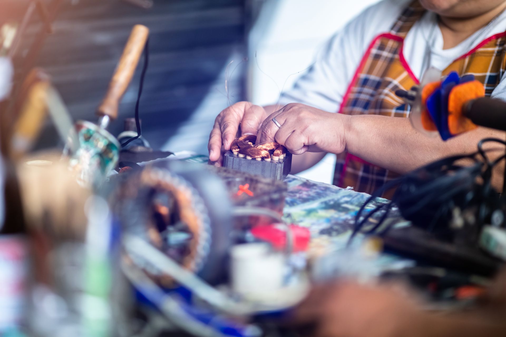 Mechanic is repairing an electric motor by replacing the copper coil.