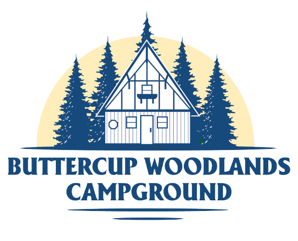 Cabin in forest, Buttercup Woodlands Campground logo. Blue trees, beige sun, text.