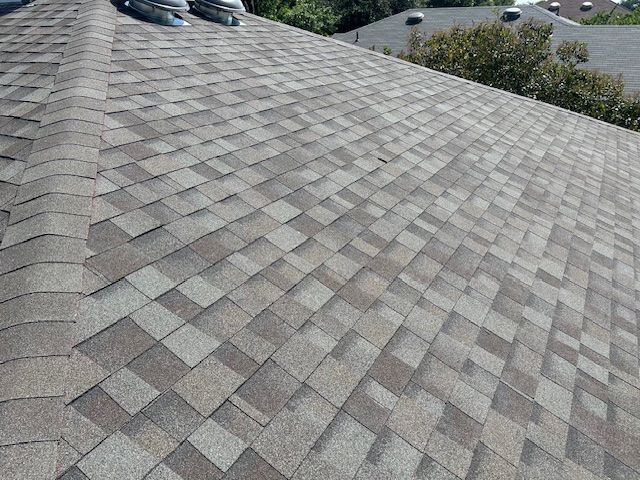 Asphalt shingle roof with varying shades of gray and brown.