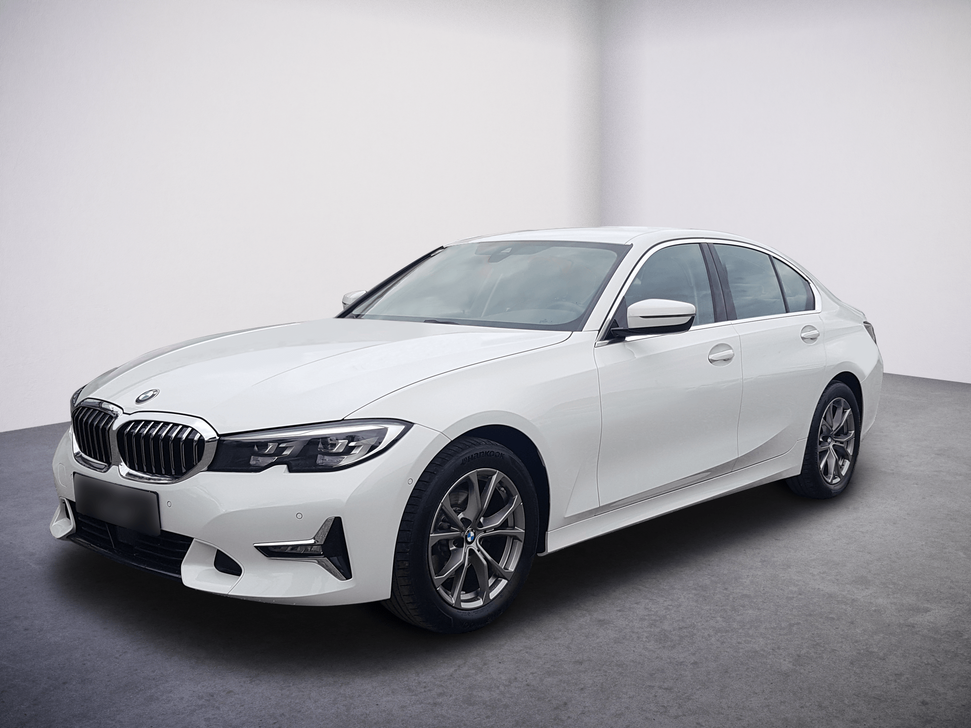 Ein weißer BMW 3er steht in einem digitalen Showroom.