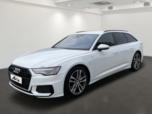 Ein weißer Audi A6 Avant steht in einem Ausstellungsraum.