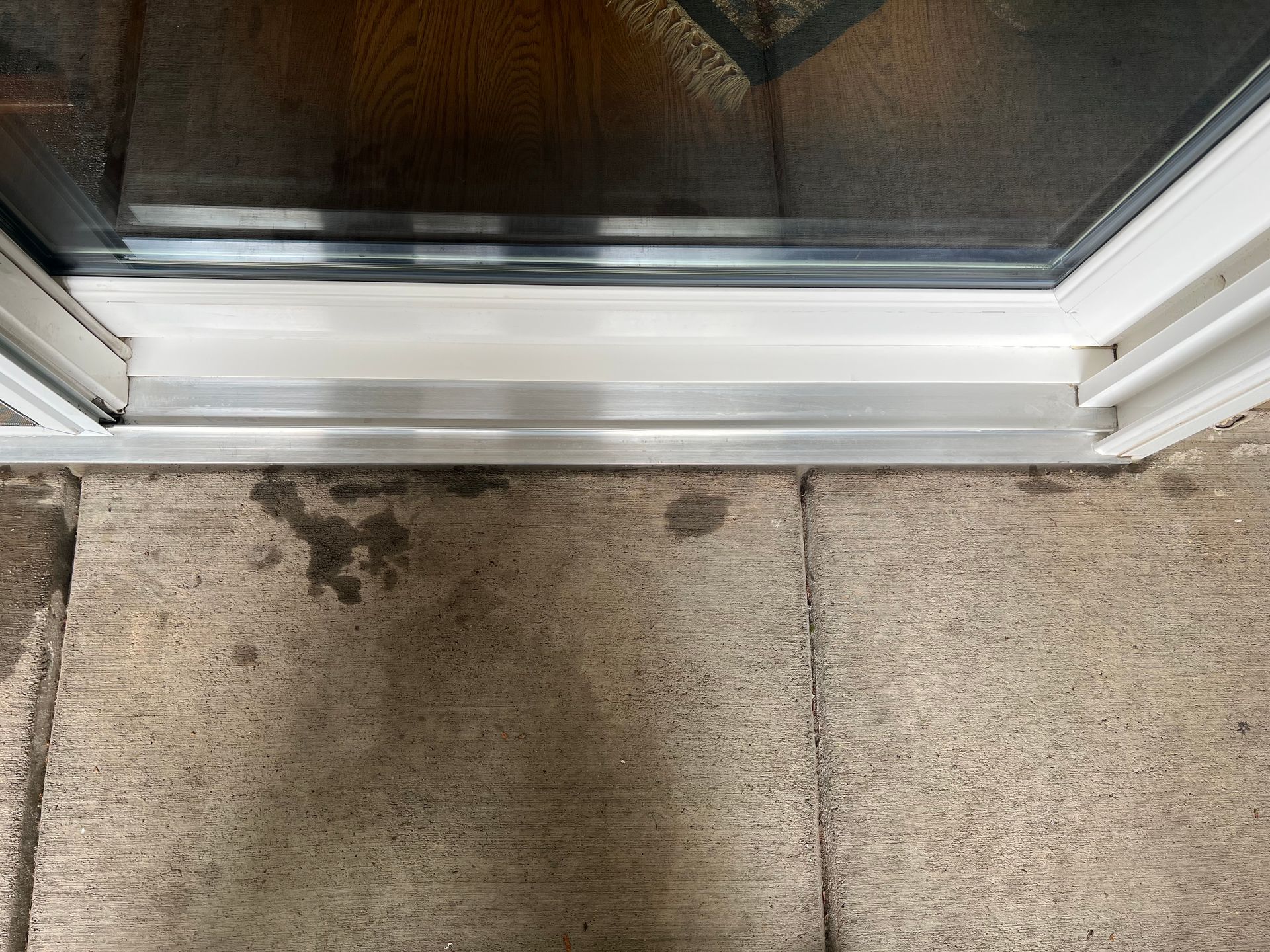 A close up of a sliding glass door on a tiled floor