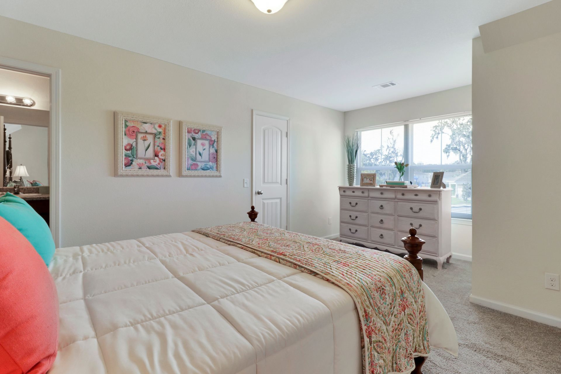 A bedroom with a king size bed and a dresser