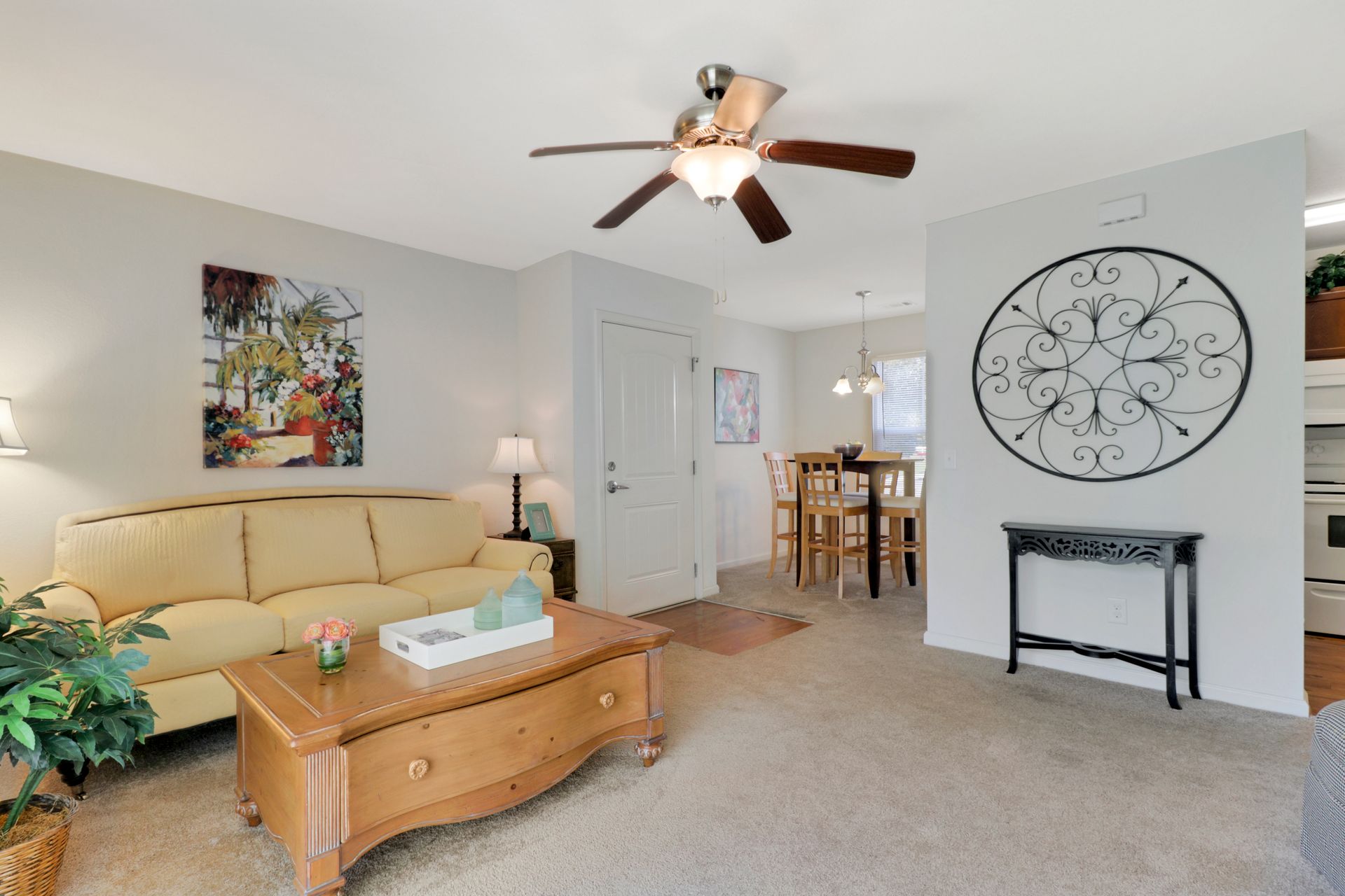 A living room with a couch , coffee table , and ceiling fan.