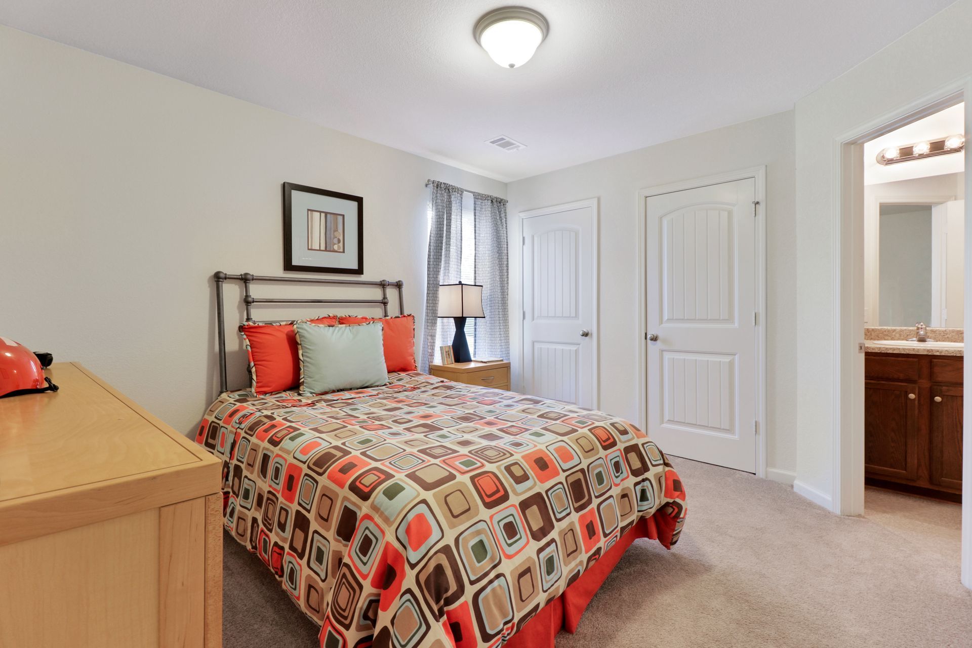 A bedroom with a large bed and a dresser