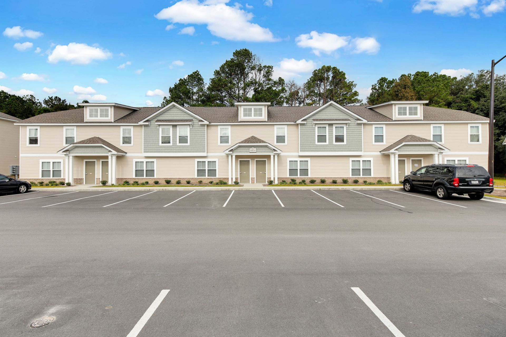 A large apartment building with cars parked in front of it