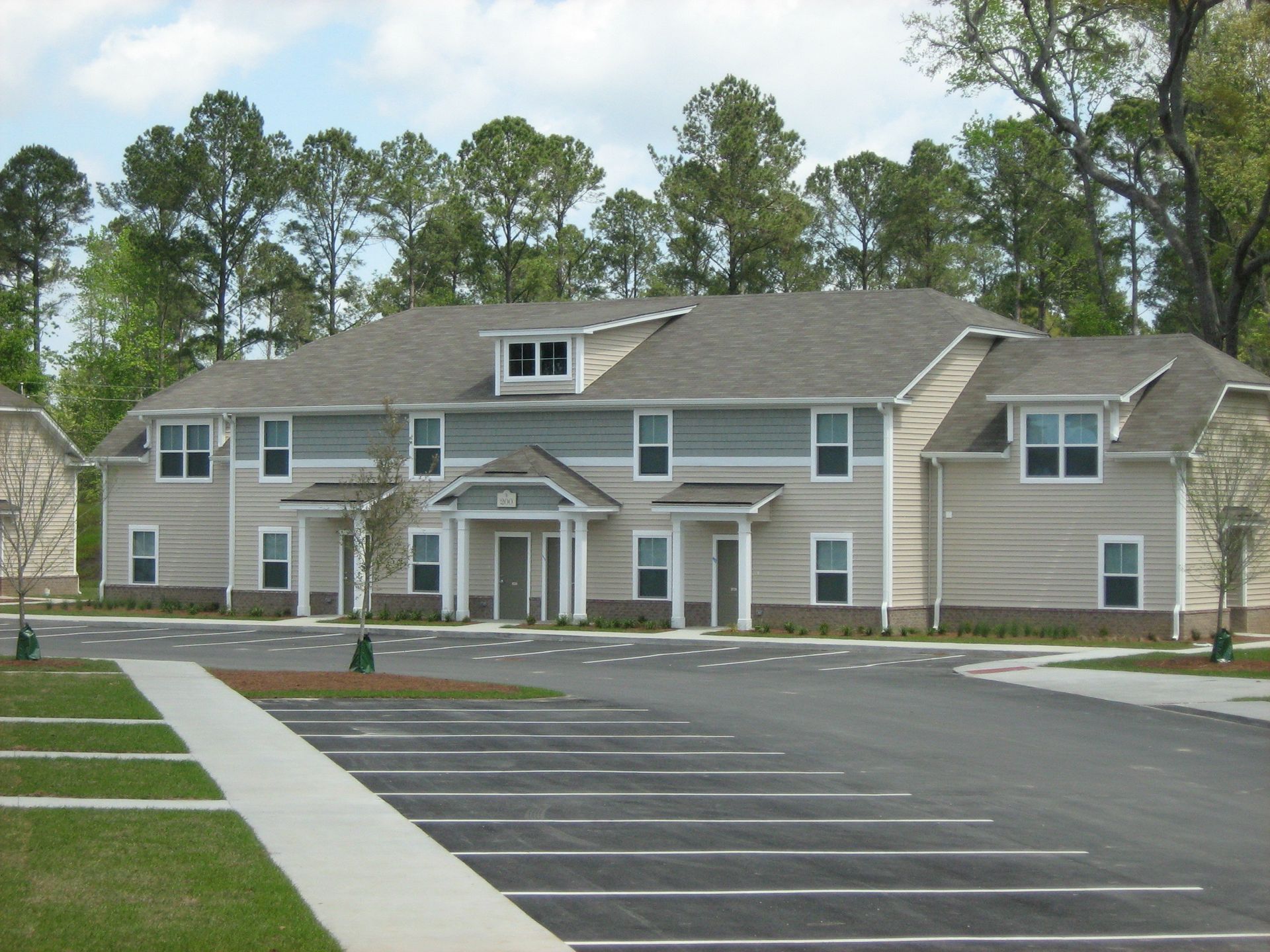 A large apartment building with a parking lot in front of it