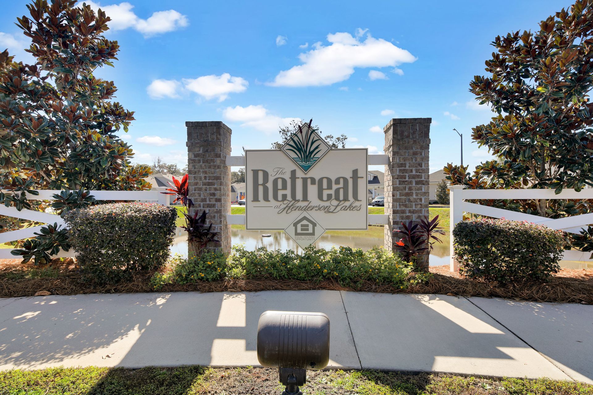 A sign that says retreat is surrounded by trees and bushes.