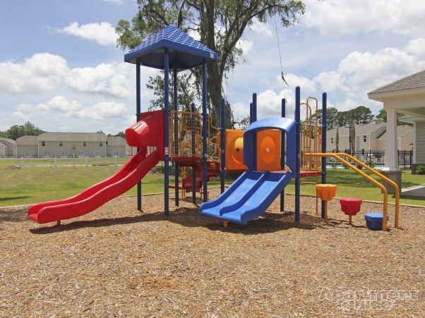 A playground with a red slide and a blue slide