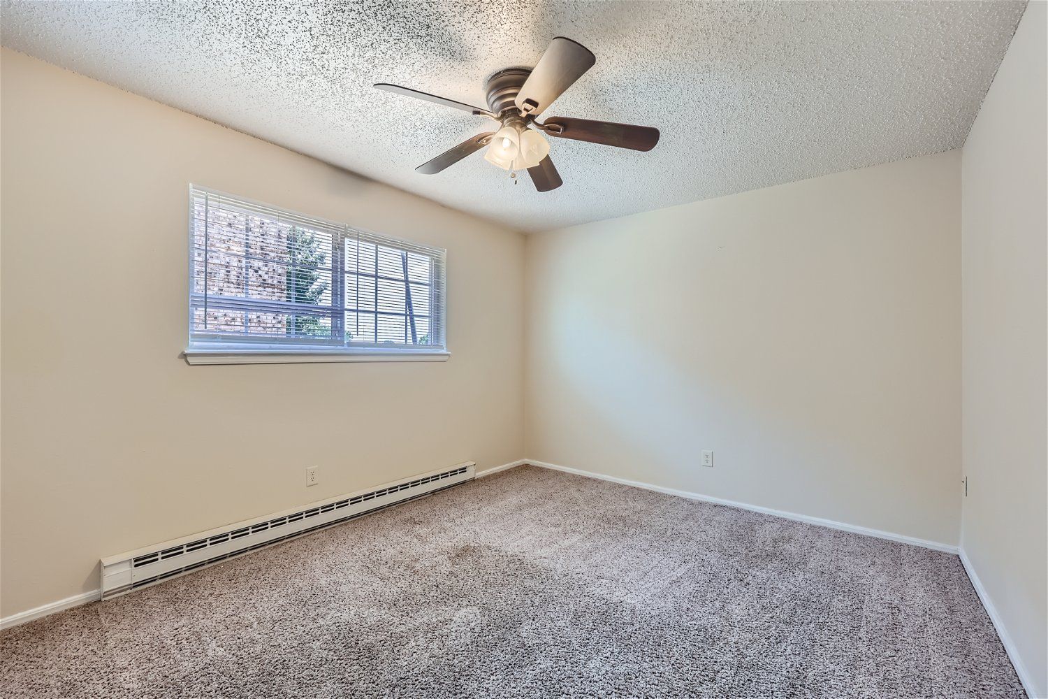 Copperstone Point bedroom with beige walls, carpet, a window with blinds, and a ceiling fan.