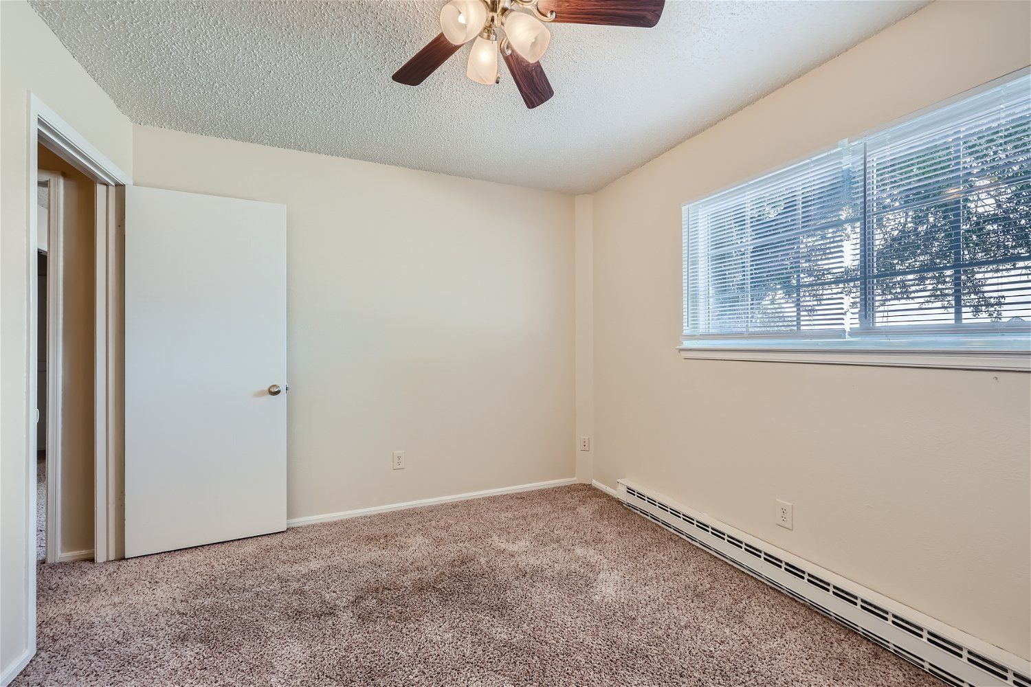 This Copperstone Point bedroom has a ceiling fan, beige walls, carpeted floor, and open closet.
