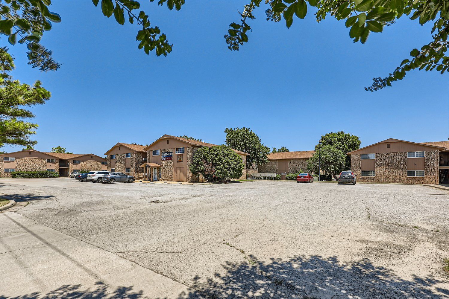 This Copperstone Point apartment community features multiple buildings with a large parking lot and trees.
