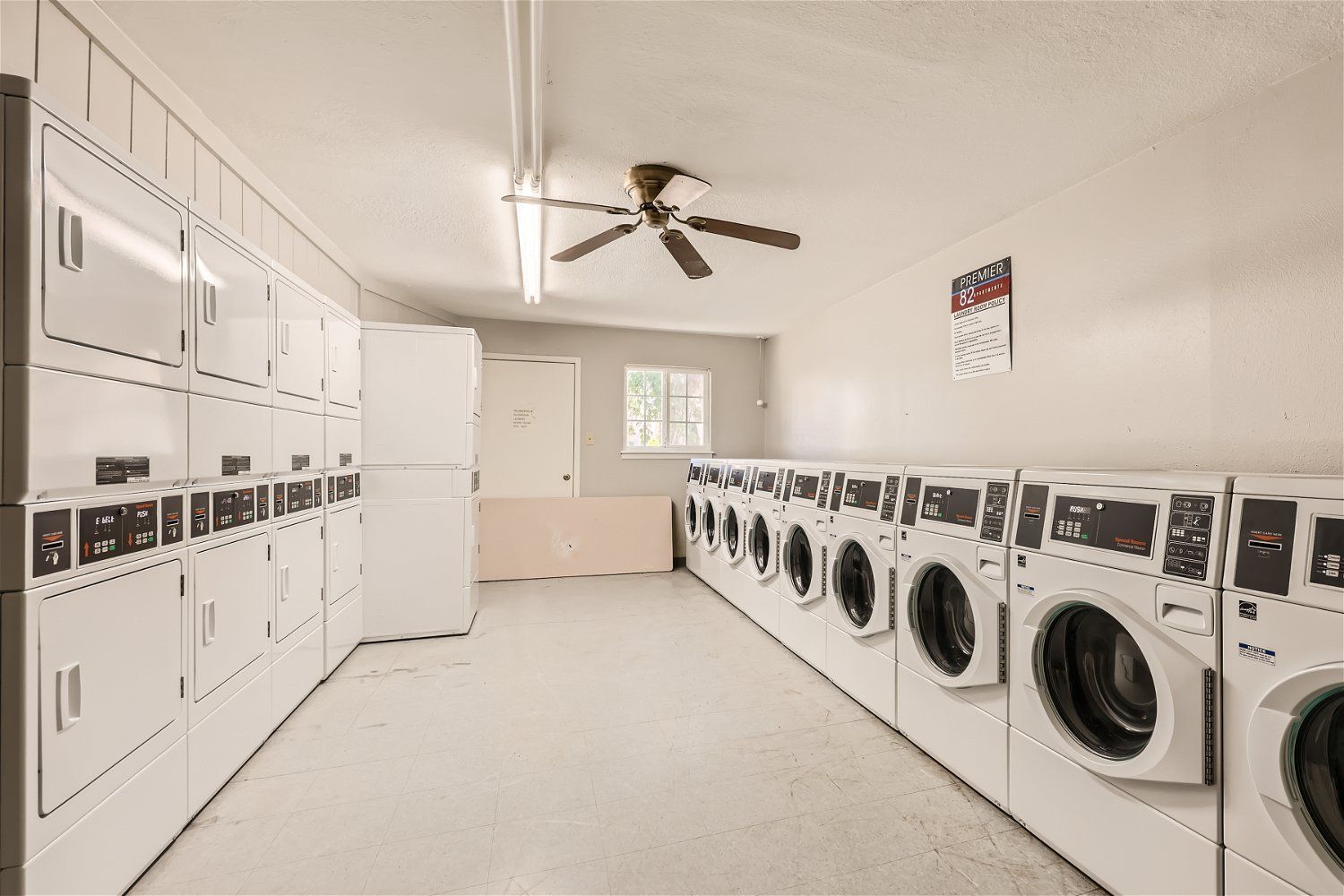 This Copperstone Point laundry room has stacked dryers  and front-loading washers.
