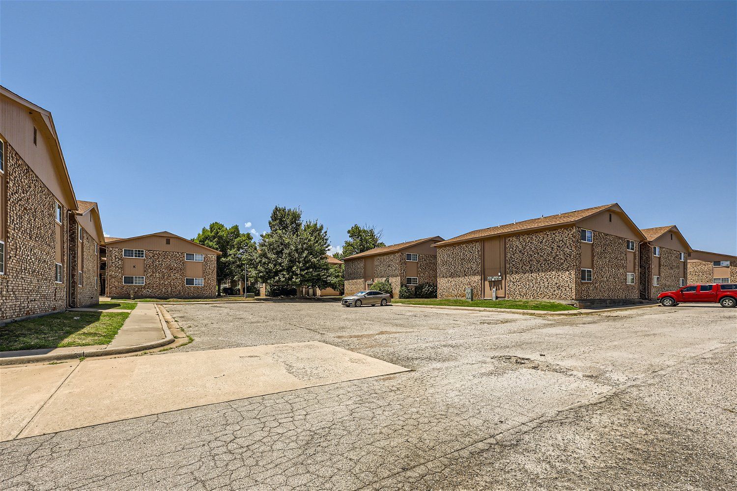 This Copperstone Point apartment complex has a brick exterior with a parking lot.