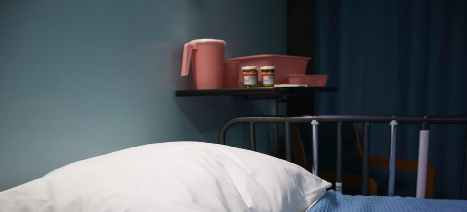 Bed with medication on a side table.