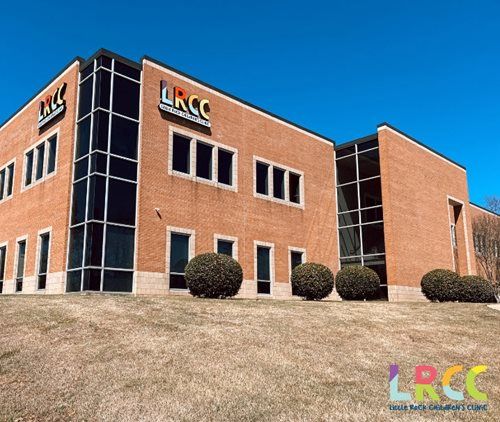 Exterior of the LRCC building, a two-story brick building with black-framed windows, against a blue sky.