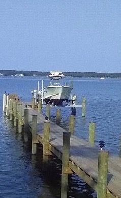 A Boat Is Being Lifted by A Crane in A Marina.