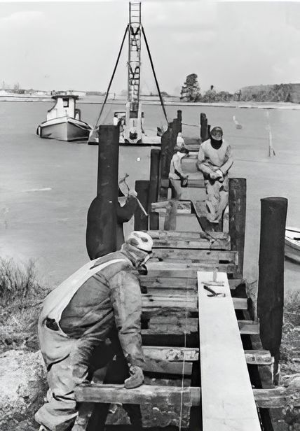 A Black and White Photo of Men Working on A Dock
