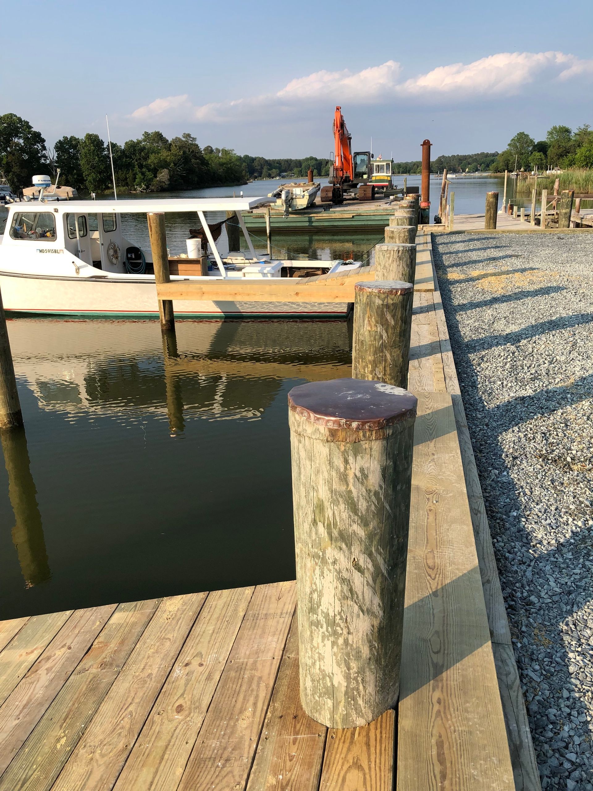 A Yellow Excavator Is Working on A Pier in The Ocean.