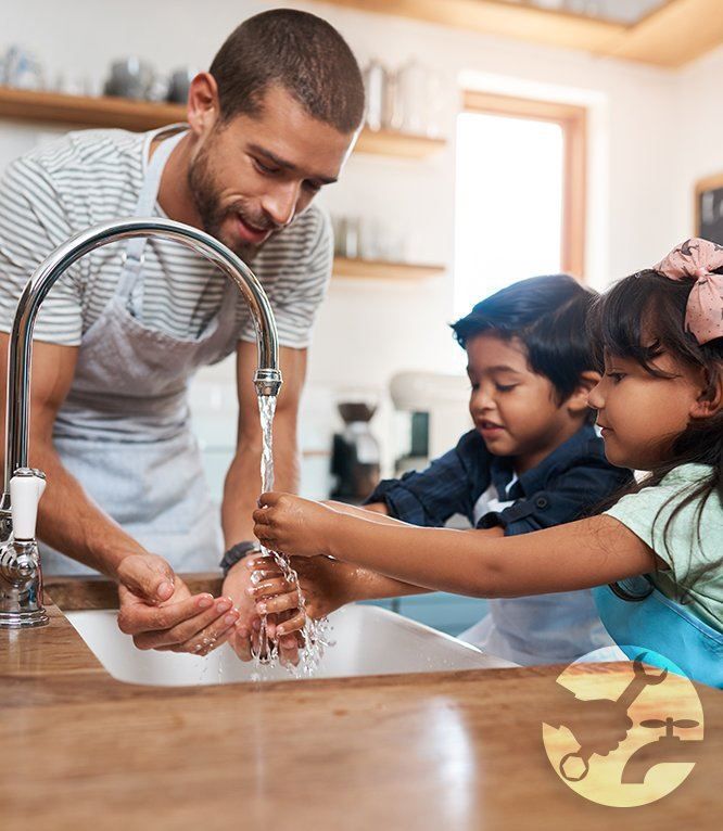 Man and two children washing hands at a kitchen sink with running water.