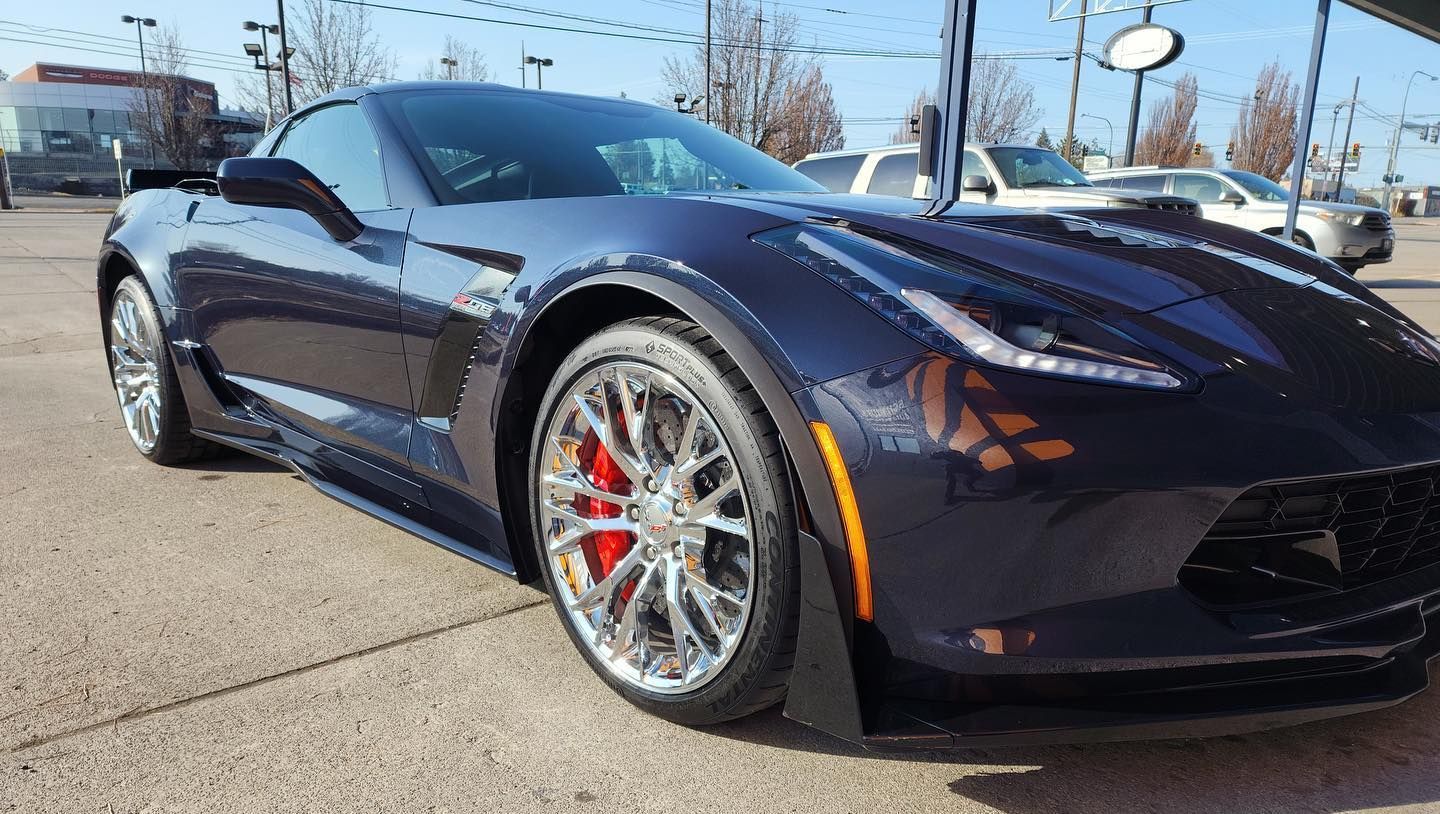A blue sports car is parked in a parking lot.